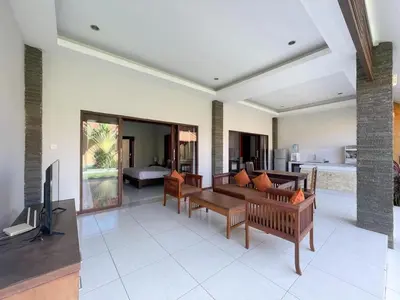 a living room with couches and a flat screen tv at The Lavana Bali Radiance Arjuna Villa Seminyak in Seminyak