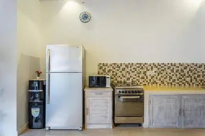 a kitchen with a refrigerator and a stove at villa mangga 2 chambres seminiak in Seminyak