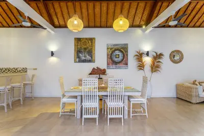 a dining room with a table and chairs at villa mangga 2 chambres seminiak in Seminyak