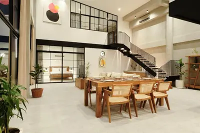 a dining room with a table and a staircase at Manresa Villa Bali 1 in Canggu