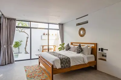 a bedroom with a bed and a large window at Manresa Villa Bali 1 in Canggu