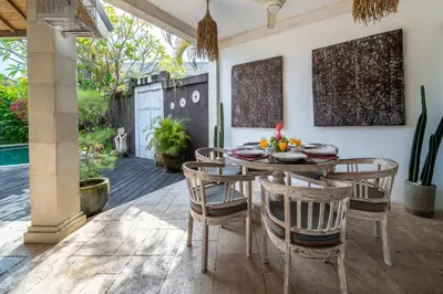a dining room with a table and chairs on a patio at Villa Armani Seminyak in Seminyak