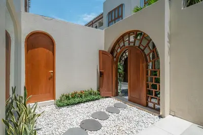 an entry to a house with two wooden doors at Alegria de la Vida in Canggu