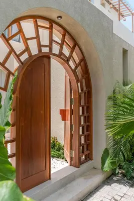 an arched entryway to a house with a wooden door at Alegria de la Vida in Canggu