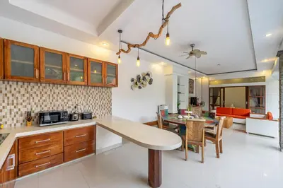 a kitchen and living room with a table and a dining room at De Gani in Seminyak