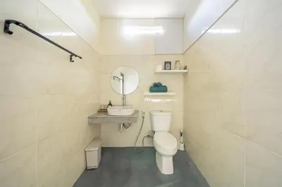 a bathroom with a toilet and a sink and a mirror at De Gani in Seminyak