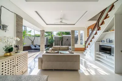 a living room with a couch and a staircase at De Gani in Seminyak