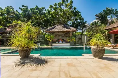 a swimming pool with a gazebo and palm trees at Luxury Villa AnTan Central Seminyak in Seminyak