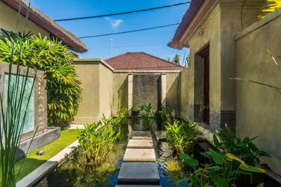 a garden outside a house with a pond at Luxury Villa AnTan Central Seminyak in Seminyak