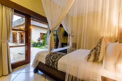 a bedroom with a bed with curtains and a window at Luxury Villa AnTan Central Seminyak in Seminyak