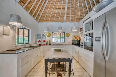 a kitchen with a table and a refrigerator at Villa Kalis, 10 BR family and group Villa in Seminyak