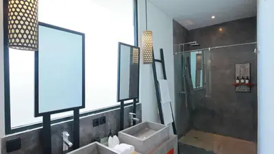 a bathroom with a sink and a shower and a mirror at Villa Sanya Berawa in Canggu