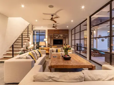 a living room with white couches and a table at Villa Sanya Berawa in Canggu