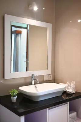 a bathroom with a white sink and a mirror at Villa Laksmi Legian in Seminyak