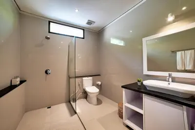 a bathroom with a sink and a toilet and a mirror at Villa Laksmi Legian in Seminyak