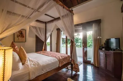 a bedroom with a canopy bed and a television at Beautiful & Luxurious 3-Bedroom Private Villa With Pool 150-Metres To Seminyak Beach in Seminyak