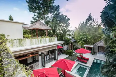 a resort with red umbrellas and a swimming pool at Beautiful & Luxurious 3-Bedroom Private Villa With Pool 150-Metres To Seminyak Beach in Seminyak
