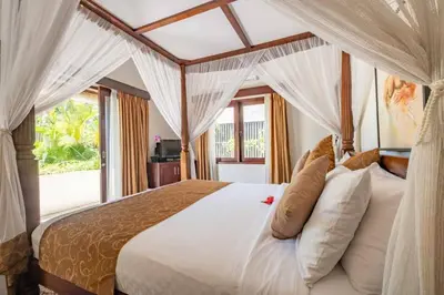 a bedroom with a large white bed with curtains at Beautiful & Luxurious 3-Bedroom Private Villa With Pool 150-Metres To Seminyak Beach in Seminyak