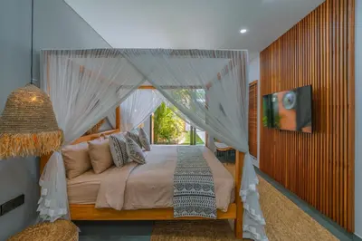 a bedroom with a canopy bed with white curtains at Villa Aless - Designer 4BR Villa with Sauna, Jacuzzi, Ice Bath, Gym & Rooftop in Canggu