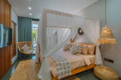 a bedroom with a bed with a canopy at Villa Aless - Designer 4BR Villa with Sauna, Jacuzzi, Ice Bath, Gym & Rooftop in Canggu