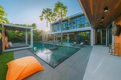 a large house with a swimming pool in front of it at Villa Aless - Designer 4BR Villa with Sauna, Jacuzzi, Ice Bath, Gym & Rooftop in Canggu
