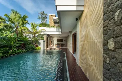 an infinity pool in the backyard of a house at The Amarta Villa in Jimbaran