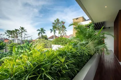 a balcony with lush green plants at The Amarta Villa in Jimbaran