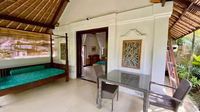 a dining room with a table and a couch at Blind Dog Inn in Sanur