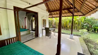 an outside view of a house with a dining table at Blind Dog Inn in Sanur