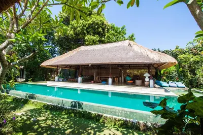 a resort with a swimming pool with a hut at Blind Dog Inn in Sanur