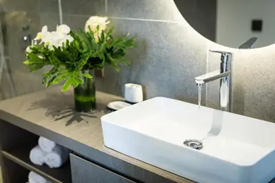 a bathroom with a sink and a vase of flowers at 20 Suites Umalas in Canggu