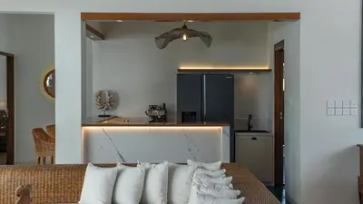 a room with a bed with pillows and a kitchen at Villa Emmy by Elite Havens in Seminyak