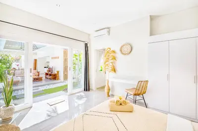 a living room with white walls and a glass door at PROMO 3BD Tropical Villa in Central Umalas in Canggu