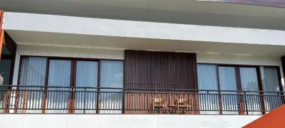 a building with a balcony with a table and chairs at Tatkala Villa Seminyak in Seminyak