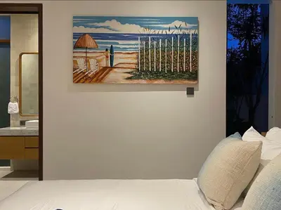 a bedroom with a painting on the wall next to a bed at Tatkala Villa Seminyak in Seminyak