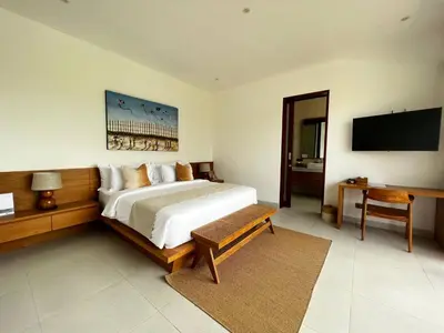 a bedroom with a bed and a flat screen tv at Tatkala Villa Seminyak in Seminyak