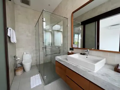 a bathroom with a sink and a shower and a mirror at Tatkala Villa Seminyak in Seminyak