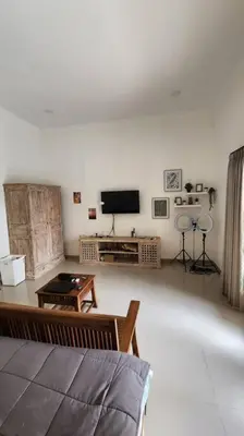 a living room with a couch and a flat screen tv at Villa Keane Bali 2 BR, Private Pool in Seminyak
