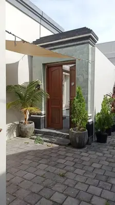 a house with two potted plants in front of a door at Villa Keane Bali 2 BR, Private Pool in Seminyak