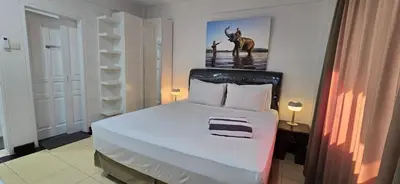 a bedroom with a white bed with a deer on the wall at The Palmana Tropical Roofline Jayakarta Residence 50 in Legian