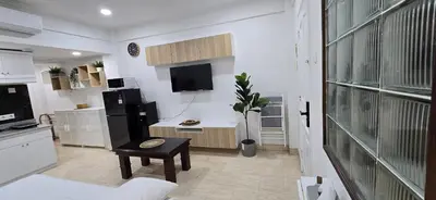 a living room with a kitchen with a black and white at The Palmana Tropical Roofline Jayakarta Residence 50 in Legian