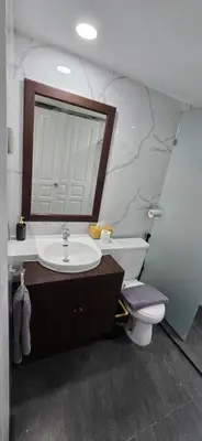 a bathroom with a sink and a toilet and a mirror at The Palmana Tropical Roofline Jayakarta Residence 50 in Legian