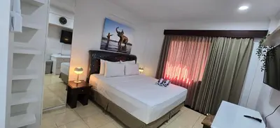 a bedroom with a large bed and a window at The Palmana Tropical Roofline Jayakarta Residence 50 in Legian