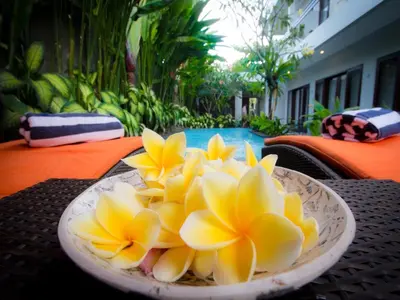 a plate of yellow flowers on a table at The Pavilion Hotel Kuta in Kuta