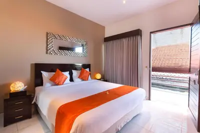 a bedroom with a large bed and a large window at The Pavilion Hotel Kuta in Kuta