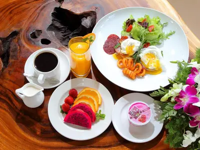 a table with two plates of food and a cup of coffee at Agata Villas Seminyak in Seminyak