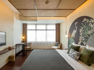 a bedroom with a large bed with a painting on the wall at The Isvara by Cove in Seminyak