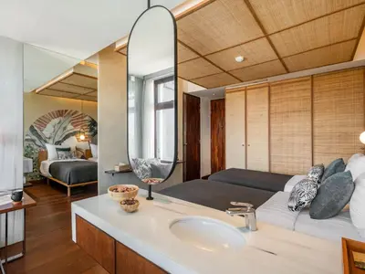 a bathroom with a sink and a large mirror at The Isvara by Cove in Seminyak