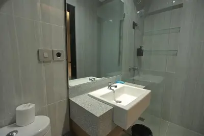 a bathroom with a sink and a toilet and a mirror at Aralea Coliving in Denpasar