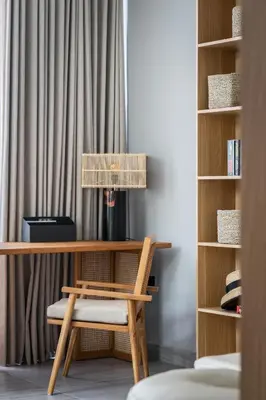 a desk with a chair next to a book shelf at Ananda Villa by Betterplace in Jimbaran